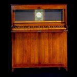 small upright piano with a folding keyboard